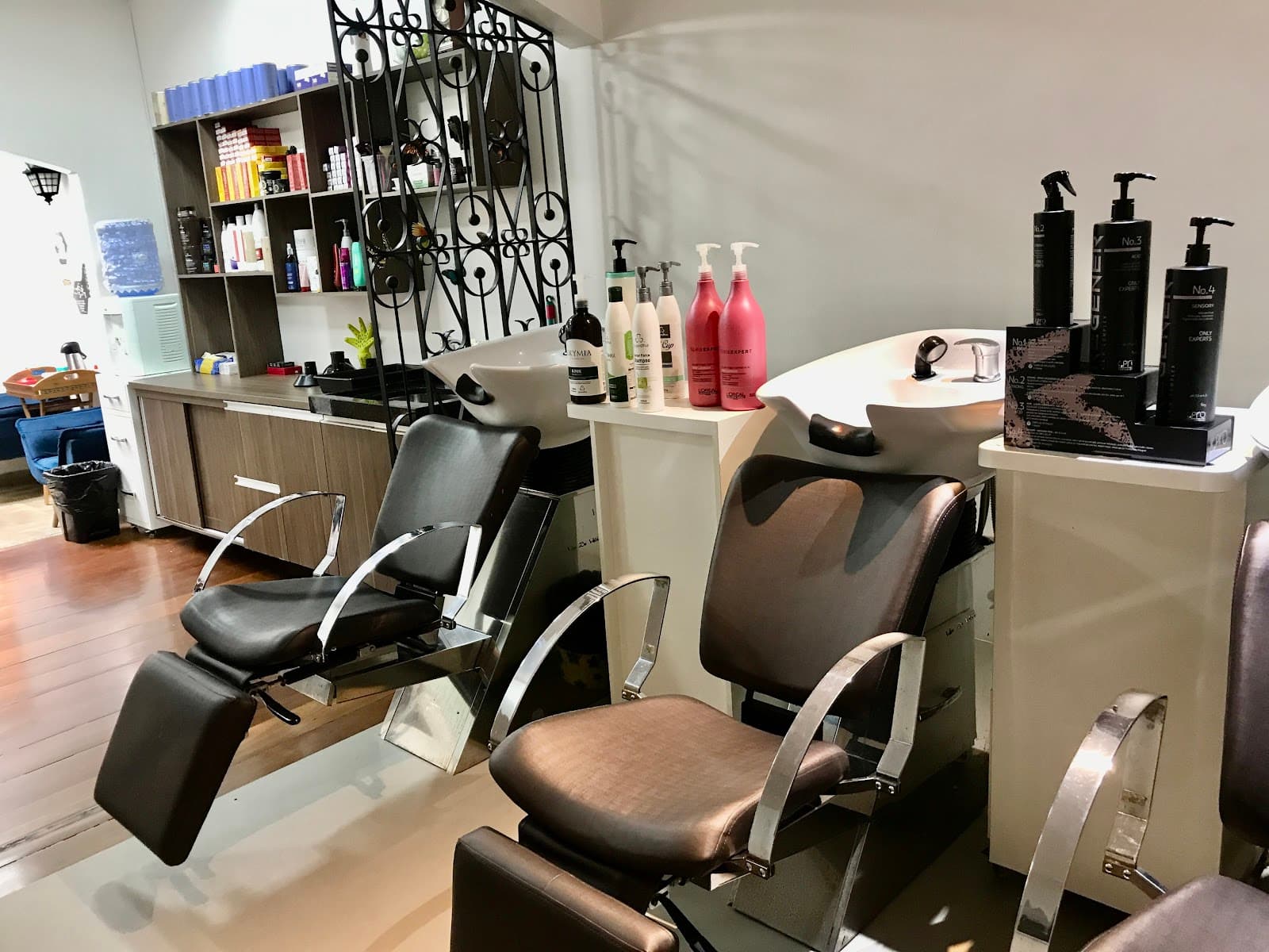 Lavatórios com cadeiras pretas reclináveis e prateleira de produtos
