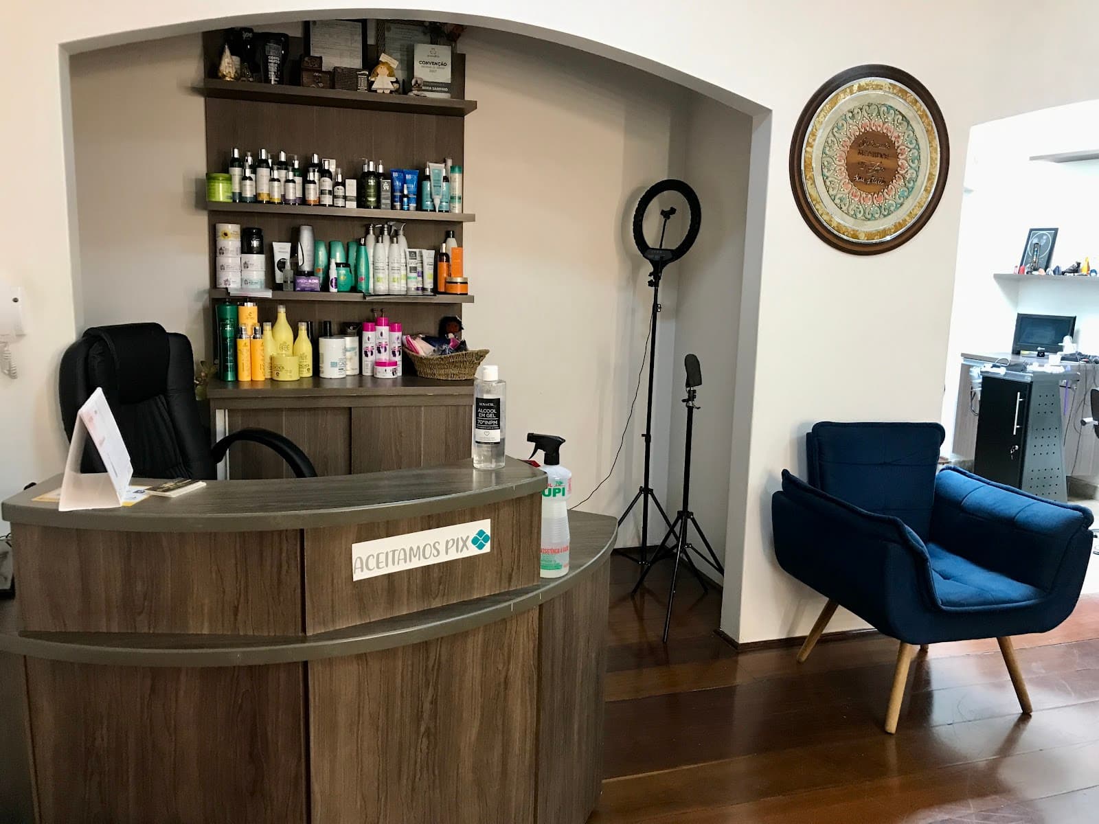 Recepção de madeira com prateleira de produtos e poltrona azul